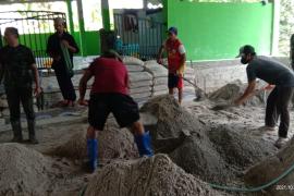 TNI dan Warga Desa Kampuri Gotong Royong Pasang Lantai Masjid Al Ikhlas