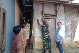 Bhabinkamtibmas Polsek Batiknau Dampingi Pasang Stiker Pada Rumah Warga