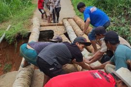 Sinergitas TNI - Polri Bersama Warga Melaksanakan Gotong Royong Membuat Jembatan Darurat di Jalan Putus 