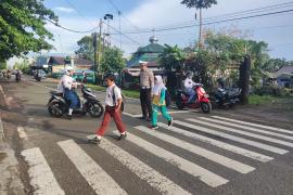 Wujud Kamseltibcar Lantas yang prima, Sat Lantas Polres BU Bantu Menyebrangkan Anak Sekolah